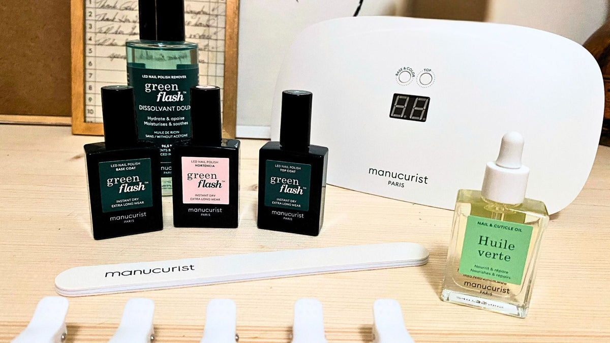Manicurist Paris full gel nail polish kit featuring an LED light, three bottles of Green Flash sustainable gel polish, a nail file, Green Flash nail polish remover, and five nail polish remover clips