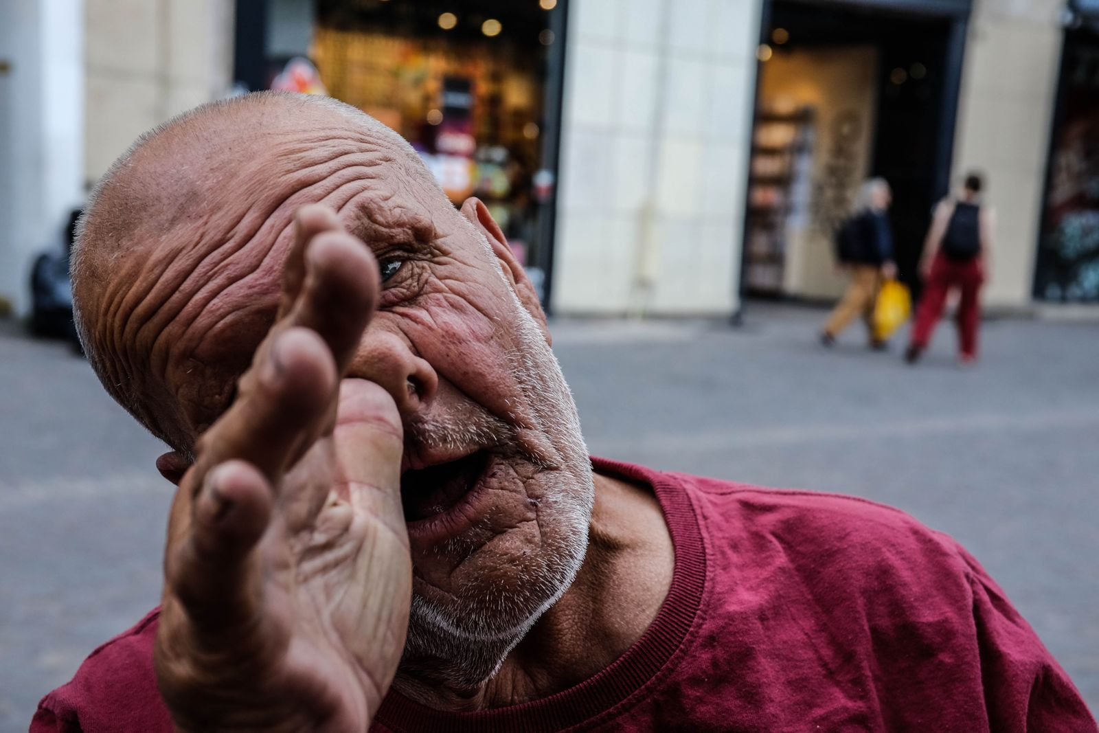 Man in Paris making a funny face at the camera. His thumb is to his nose with the rest of his hand extended.